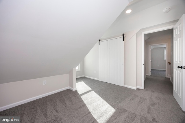 bonus room with carpet flooring and vaulted ceiling