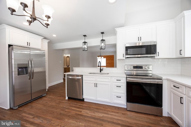 kitchen featuring pendant lighting, appliances with stainless steel finishes, sink, and white cabinets