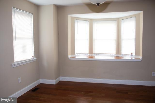 empty room with dark hardwood / wood-style flooring