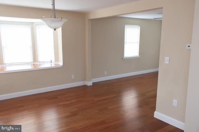 empty room with dark wood-type flooring