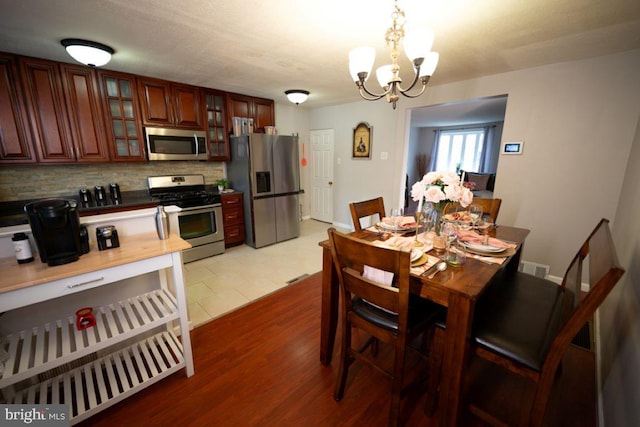 dining room with a chandelier and tile patterned flooring