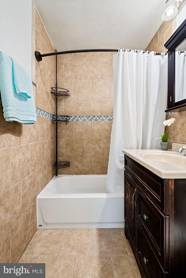 bathroom with vanity, shower / bathtub combination with curtain, and tile walls