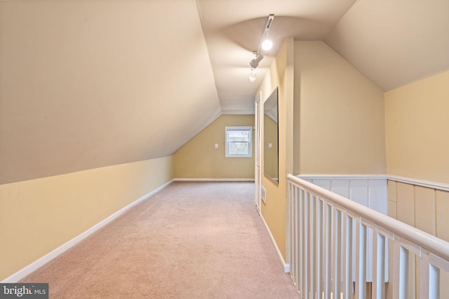 additional living space with vaulted ceiling and light carpet