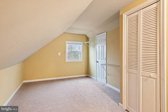 additional living space featuring light carpet and vaulted ceiling