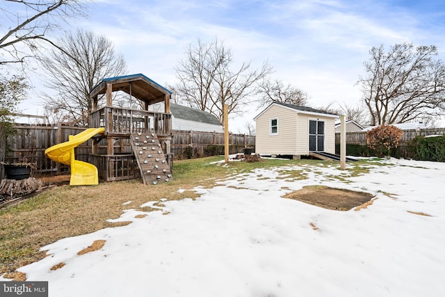 yard covered in snow featuring a shed and a playground