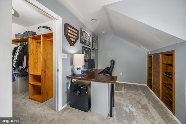 carpeted home office featuring vaulted ceiling