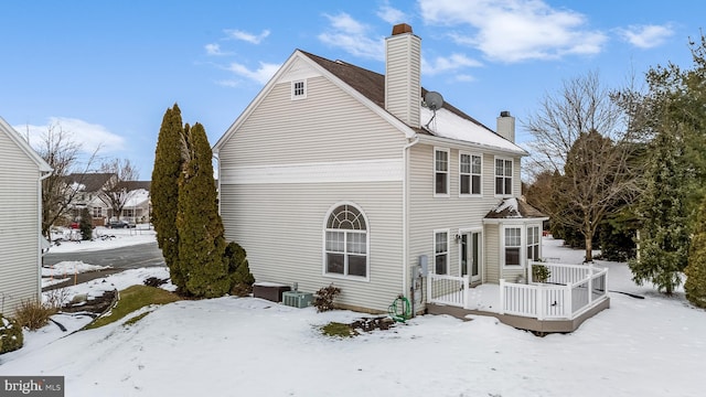 snow covered property with a deck and central air condition unit