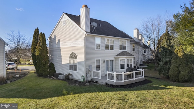 back of property with a wooden deck, a yard, and central air condition unit