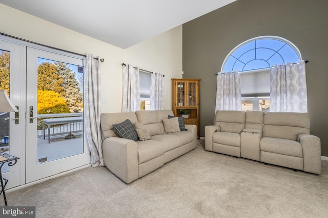 living room featuring light colored carpet, french doors, and a healthy amount of sunlight