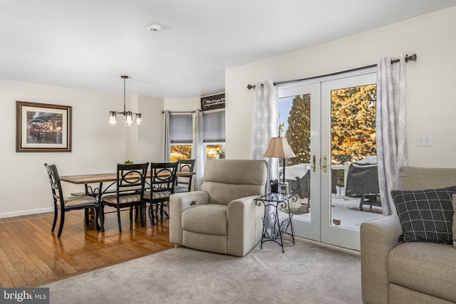 living room featuring french doors, a chandelier, and carpet flooring