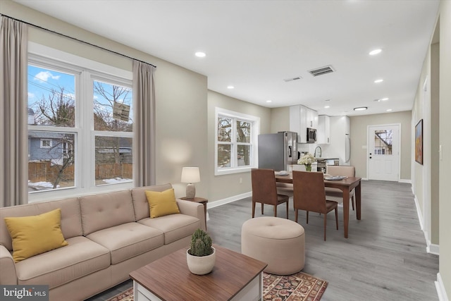 living room with sink and light hardwood / wood-style floors