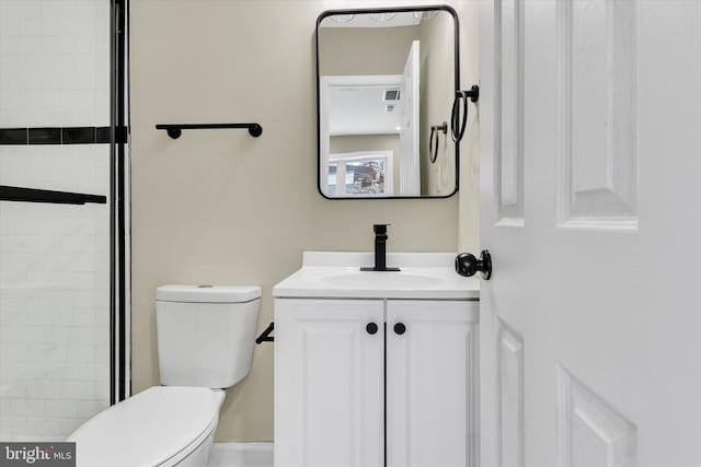 bathroom featuring toilet, an enclosed shower, and vanity