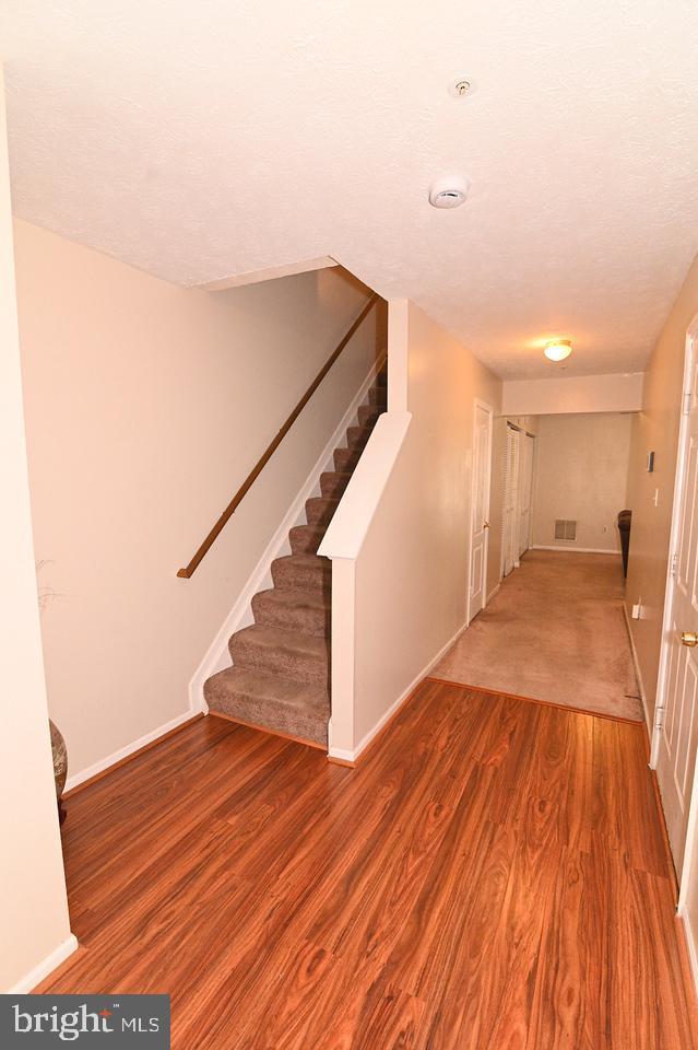 stairs featuring a textured ceiling and hardwood / wood-style flooring