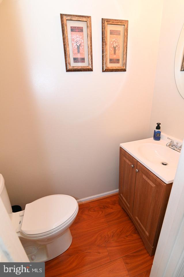 bathroom with toilet, vanity, and hardwood / wood-style flooring