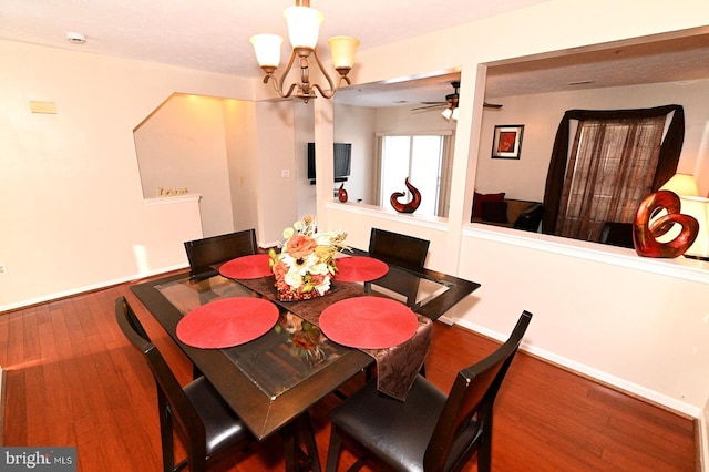 dining area featuring ceiling fan with notable chandelier and wood-type flooring