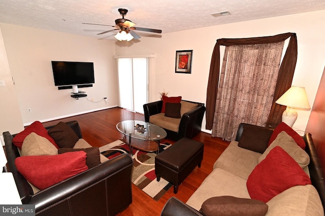 living room featuring ceiling fan, a textured ceiling, and dark hardwood / wood-style flooring