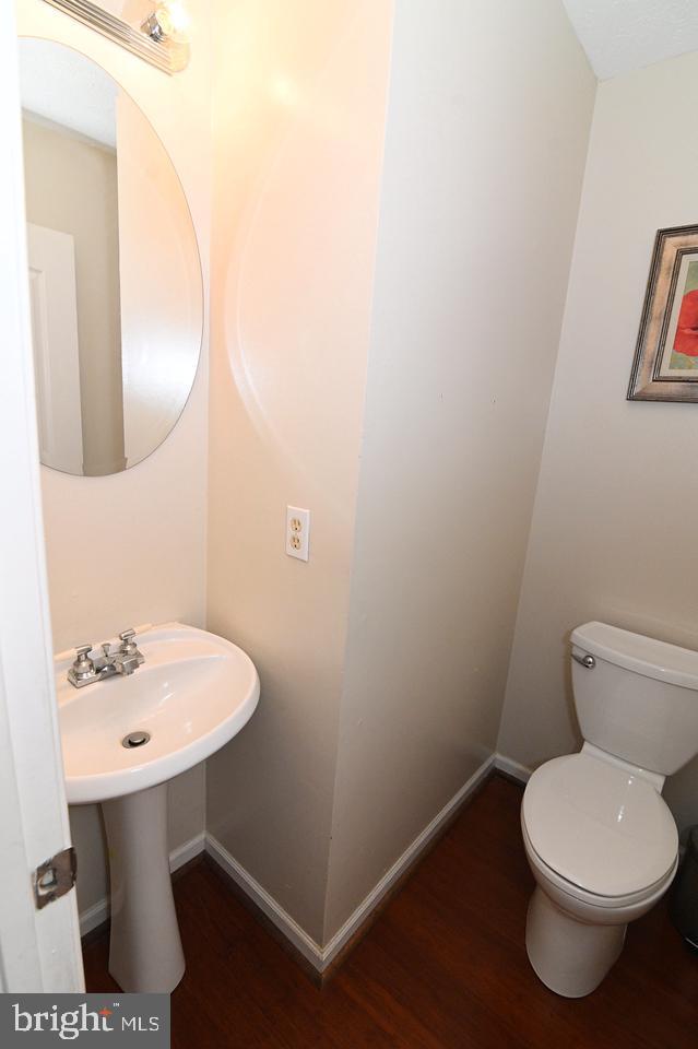 bathroom with toilet, sink, and hardwood / wood-style floors