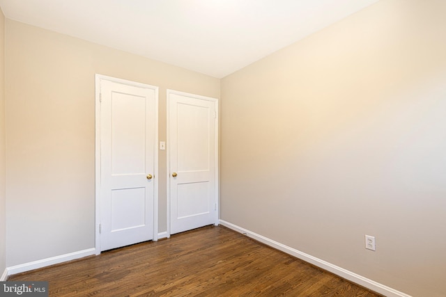 unfurnished bedroom with dark hardwood / wood-style flooring