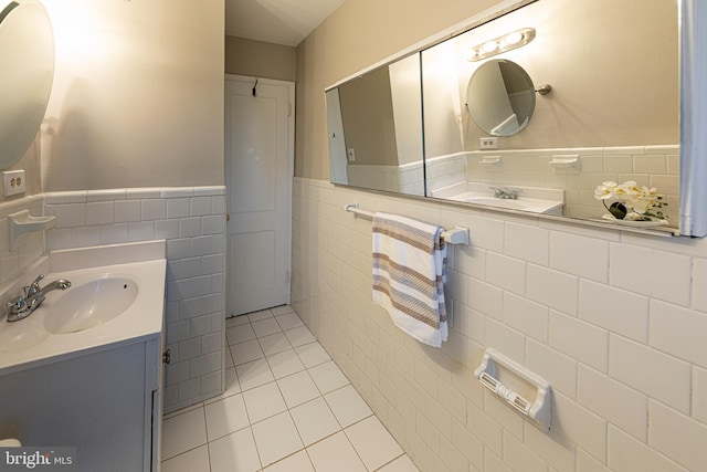 bathroom with tile walls, vanity, and tile patterned flooring