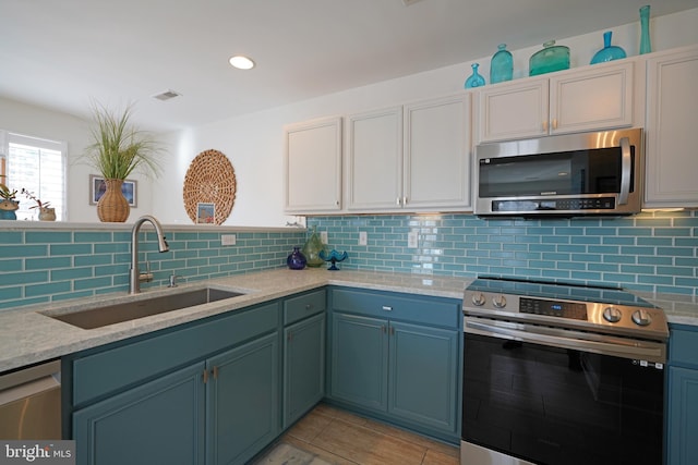 kitchen featuring sink, backsplash, white cabinetry, and stainless steel appliances