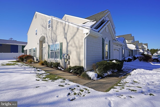 snow covered property with a garage