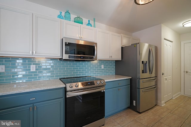 kitchen with white cabinetry, decorative backsplash, blue cabinets, stainless steel appliances, and light tile patterned flooring