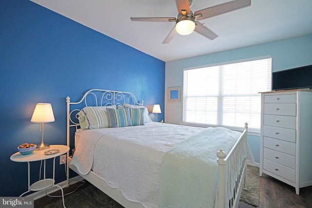 bedroom featuring ceiling fan, dark wood-type flooring, and multiple windows