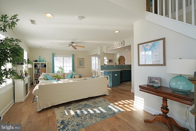 living room with sink, hardwood / wood-style flooring, and ceiling fan