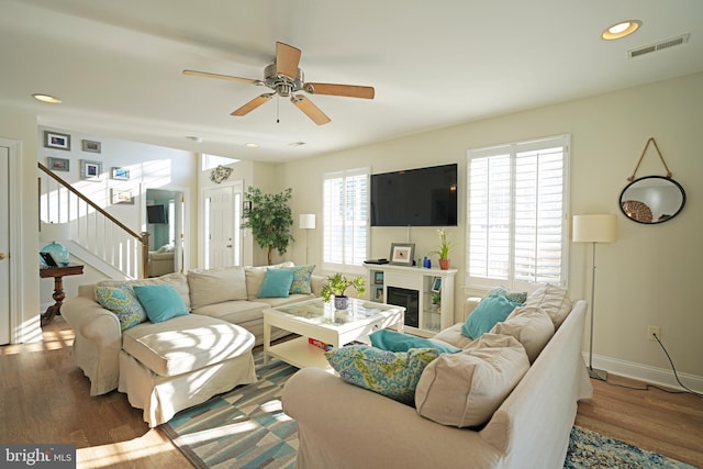 living room featuring wood-type flooring and ceiling fan