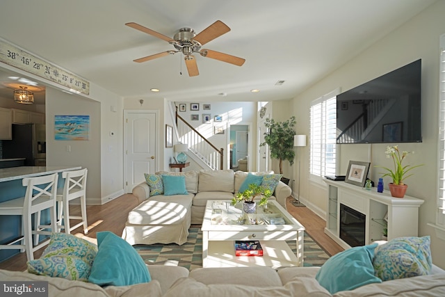 living room with light wood-type flooring and ceiling fan