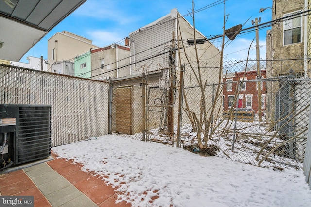 snowy yard featuring cooling unit