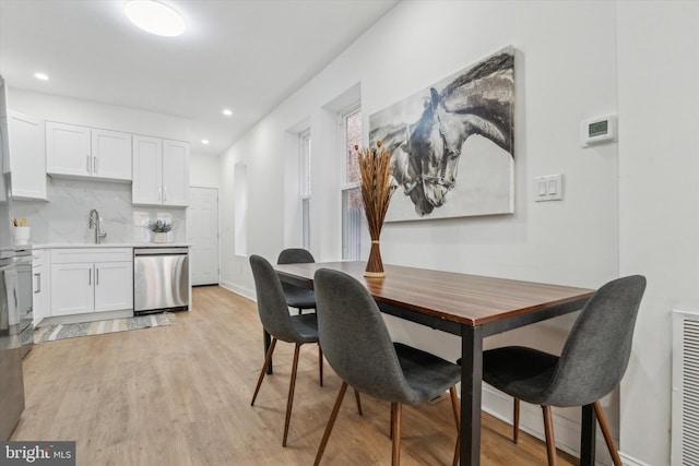 dining room with sink and light wood-type flooring