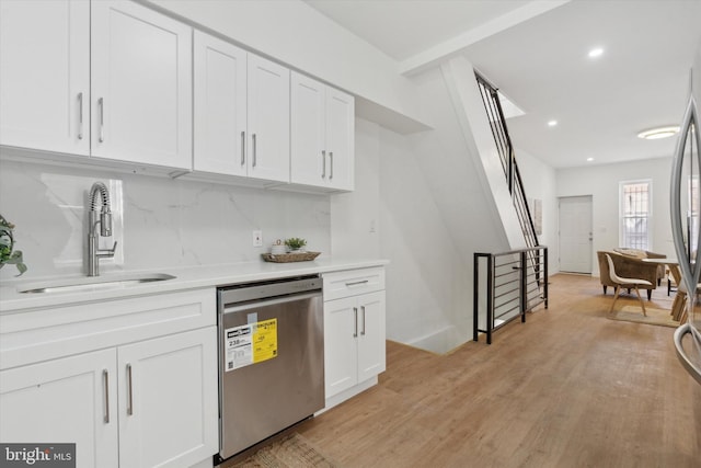 kitchen with white cabinetry, sink, stainless steel dishwasher, and decorative backsplash