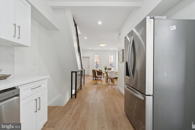 kitchen with stainless steel appliances, light hardwood / wood-style floors, and white cabinets