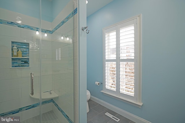 bathroom with walk in shower, tile patterned floors, and toilet