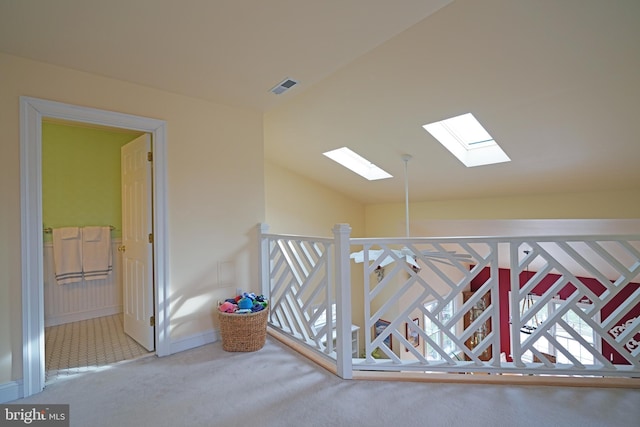 corridor featuring vaulted ceiling and carpet floors