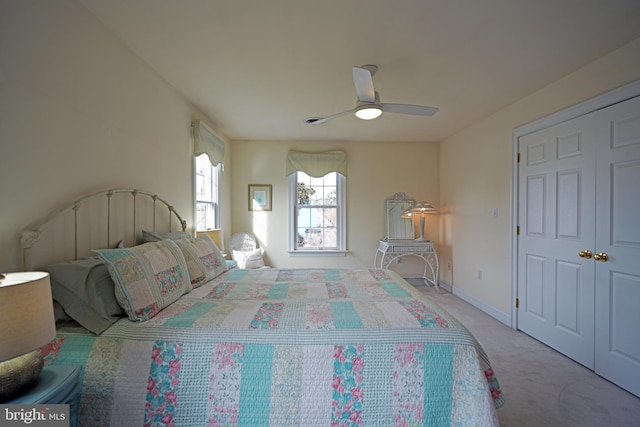 bedroom featuring light colored carpet, a closet, and ceiling fan