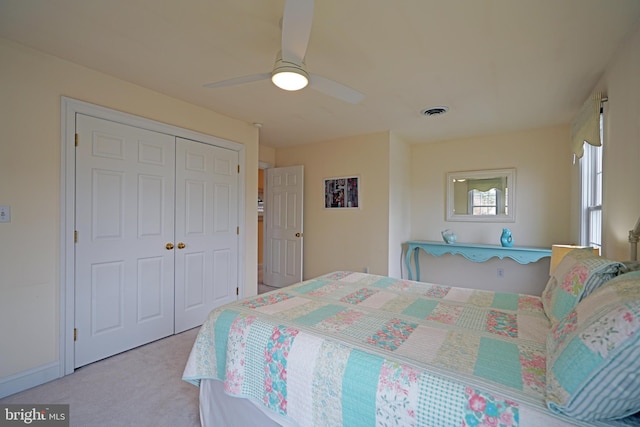 carpeted bedroom featuring ceiling fan and a closet