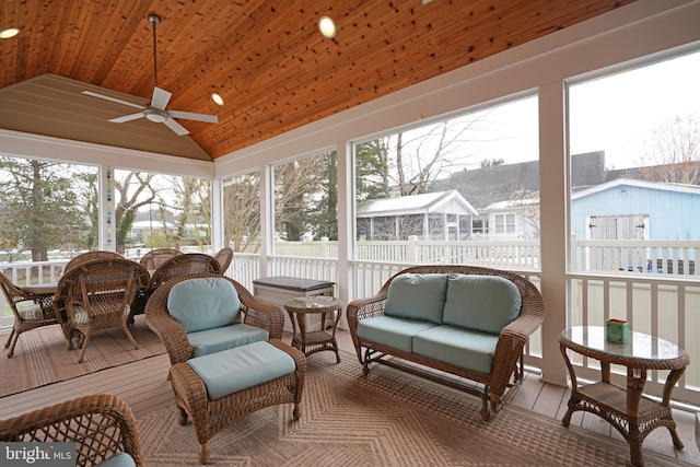 sunroom / solarium featuring vaulted ceiling, wooden ceiling, and ceiling fan