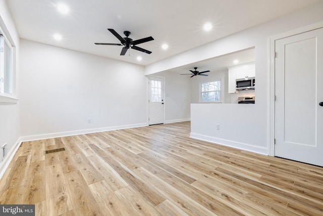 unfurnished living room with ceiling fan and light hardwood / wood-style flooring