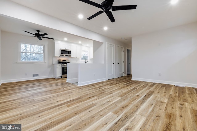 unfurnished living room featuring ceiling fan, light hardwood / wood-style floors, and sink