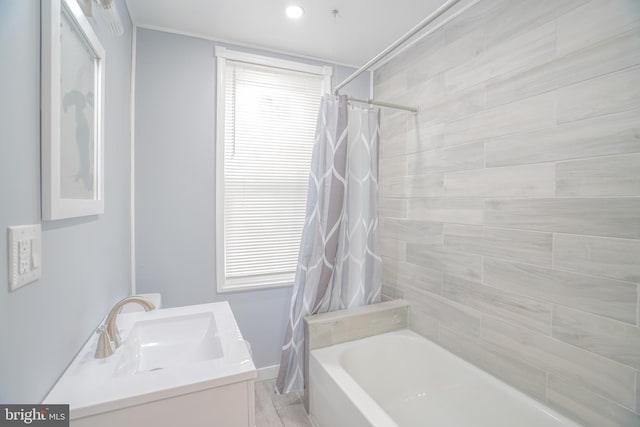 bathroom with hardwood / wood-style floors, vanity, and shower / bathtub combination with curtain