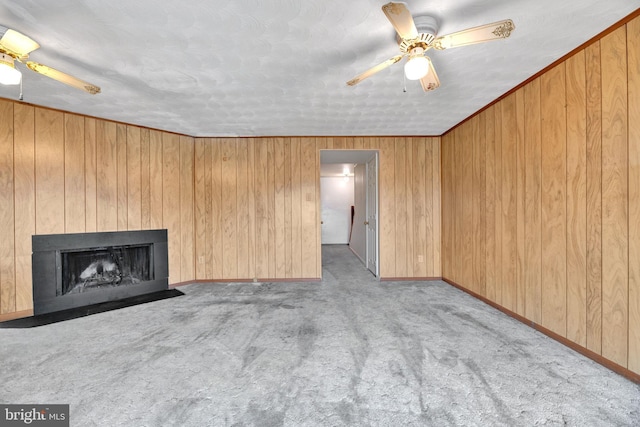 unfurnished living room featuring light colored carpet, ceiling fan, and wood walls