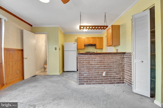 kitchen featuring crown molding, light carpet, and white fridge