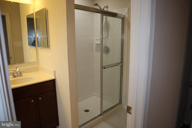 bathroom featuring walk in shower, vanity, and tile patterned flooring