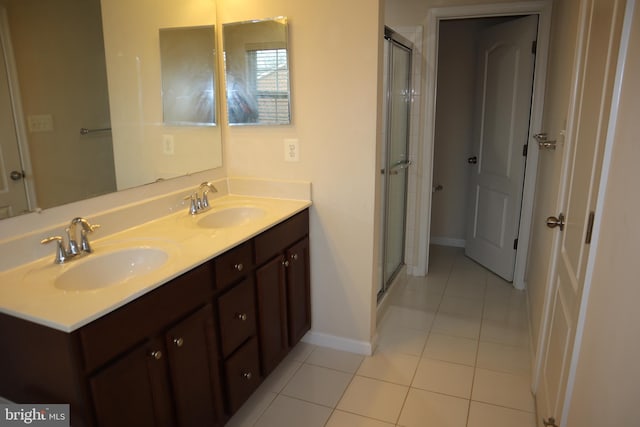 bathroom with tile patterned flooring, vanity, and walk in shower