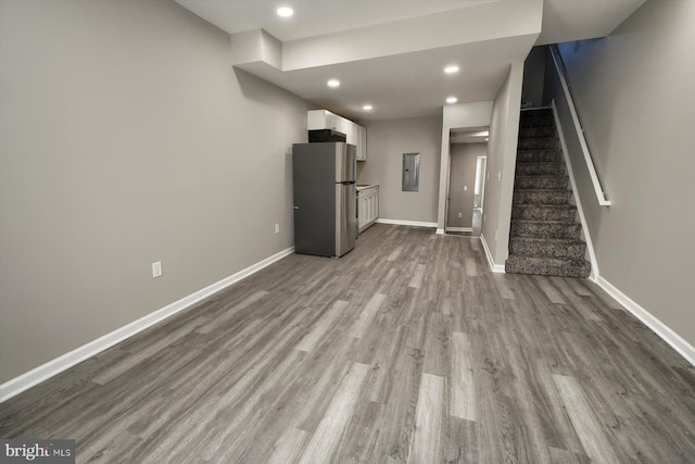 unfurnished living room with electric panel and light wood-type flooring