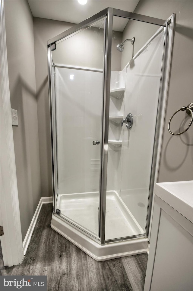 bathroom featuring an enclosed shower and hardwood / wood-style flooring