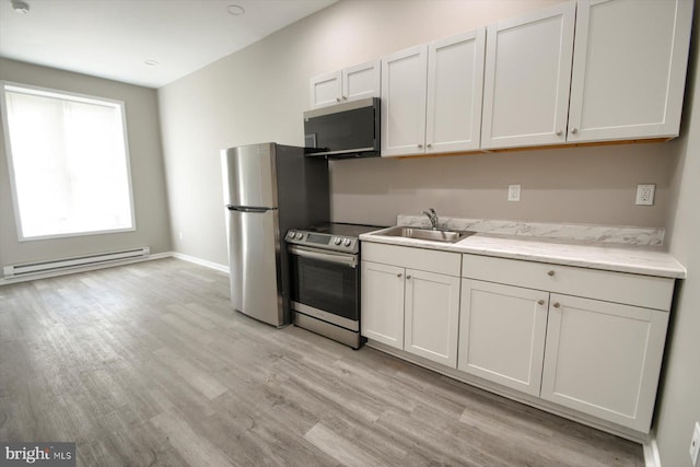 kitchen featuring a baseboard radiator, white cabinetry, sink, stainless steel appliances, and light wood-type flooring