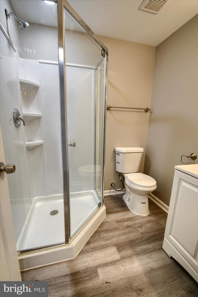 bathroom featuring vanity, toilet, an enclosed shower, and hardwood / wood-style floors